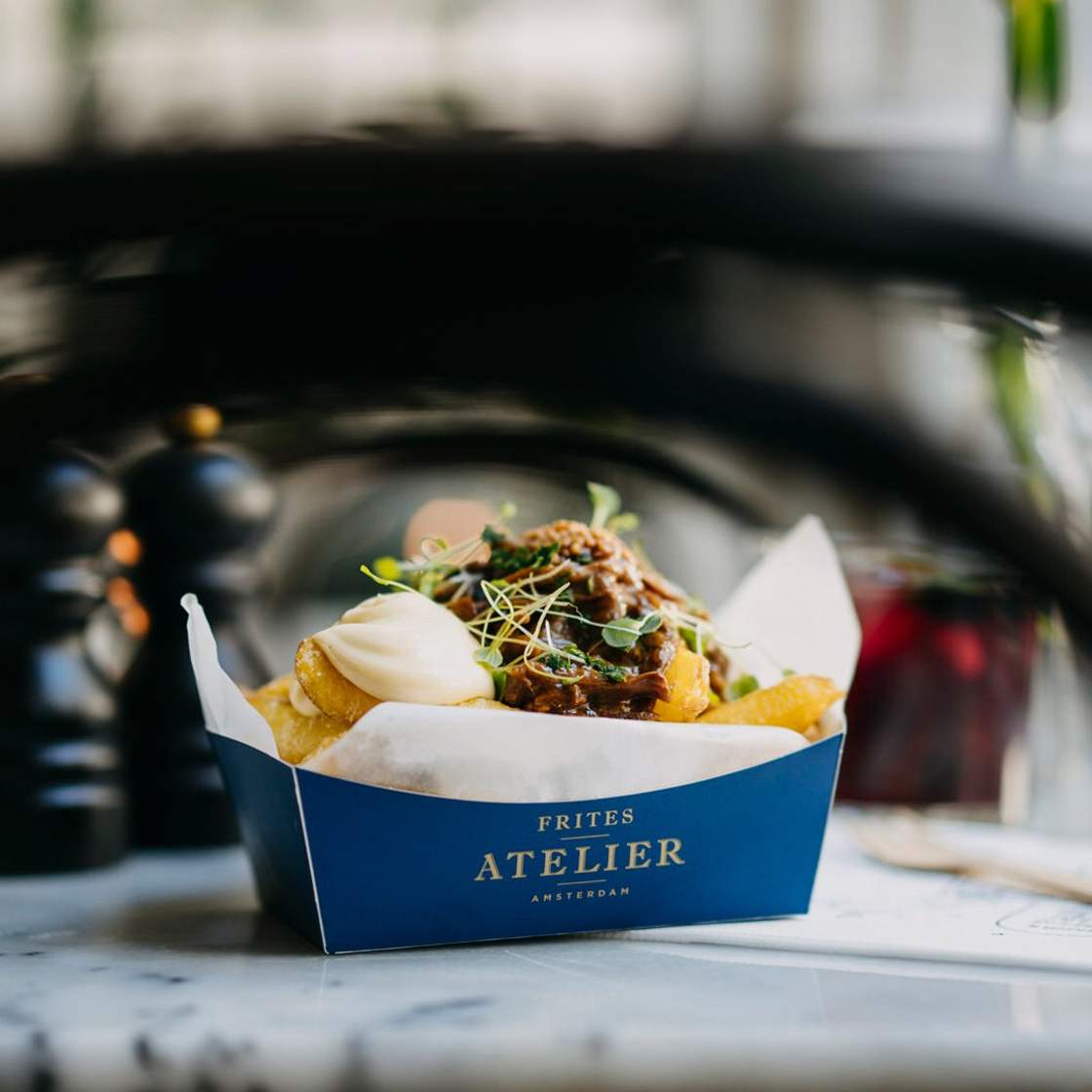 Image of fries in a box, covered by a sauce