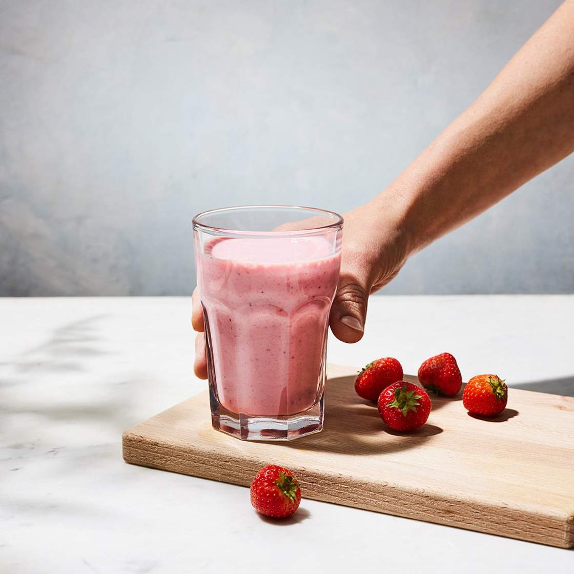 A hand grabbing a delicious smoothie