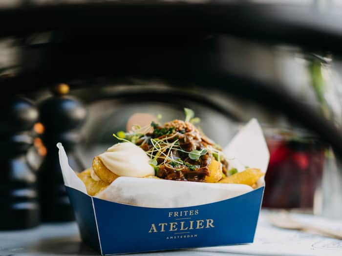 Image of fries in a box, covered by a sauce