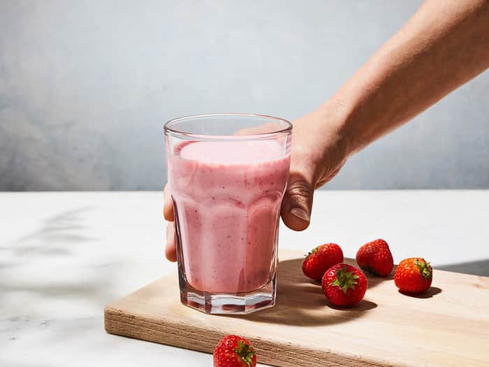 A hand grabbing a delicious smoothie