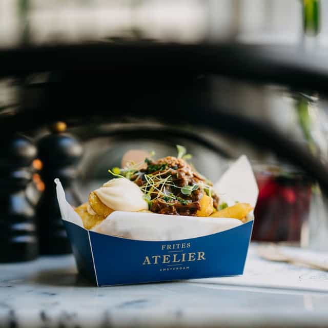 Image of fries in a box, covered by a sauce