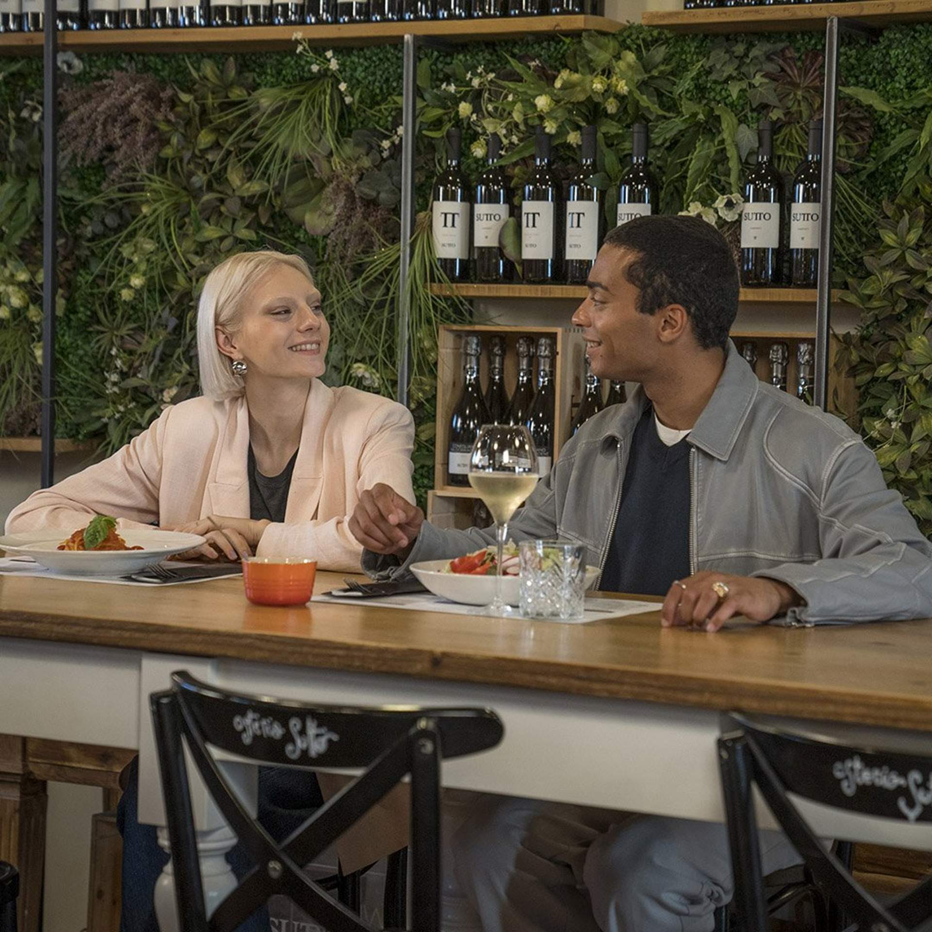 A couple sharing a pasta meal at a restaurant located at Noventa di Piave Designer Outlet.